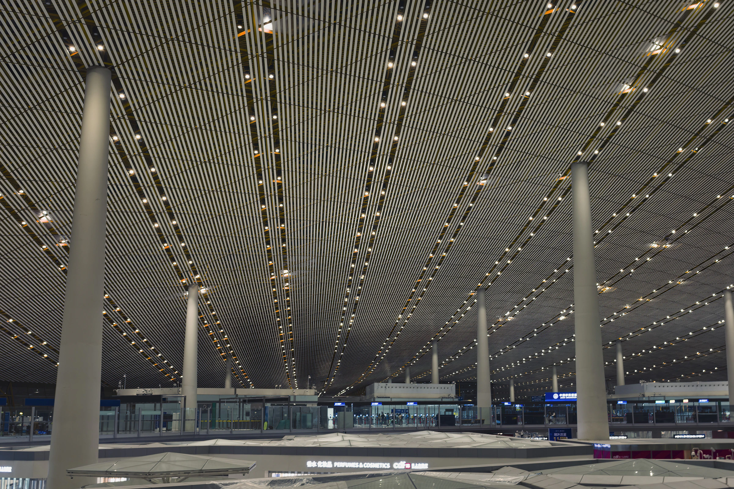 Modern airport terminal with illuminated geometric ceiling design