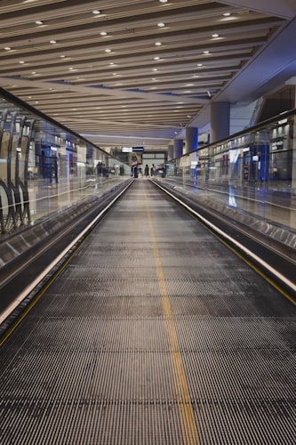 Couloir moderne d'aéroport avec tapis roulant et voyageurs