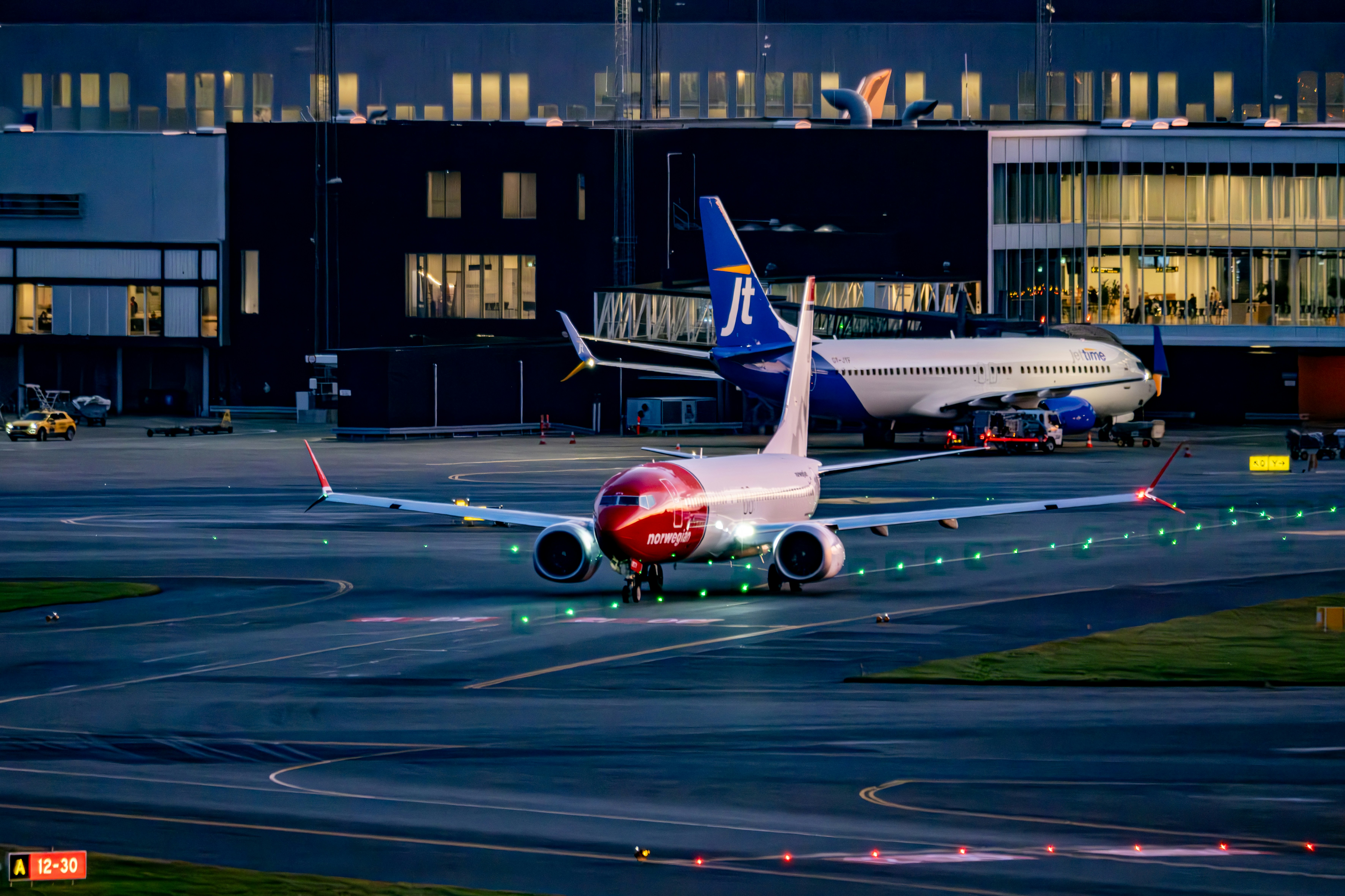Airplane taxiing on airport tarmac at dusk