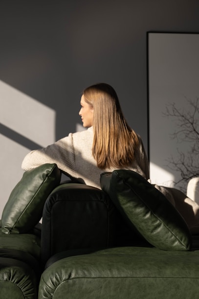 Woman sitting on a couch with sunlight.