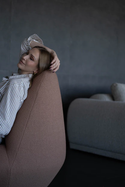 Woman relaxing in a modern chair with hand in hair
