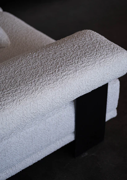 Close up of a textured white armchair with black accent