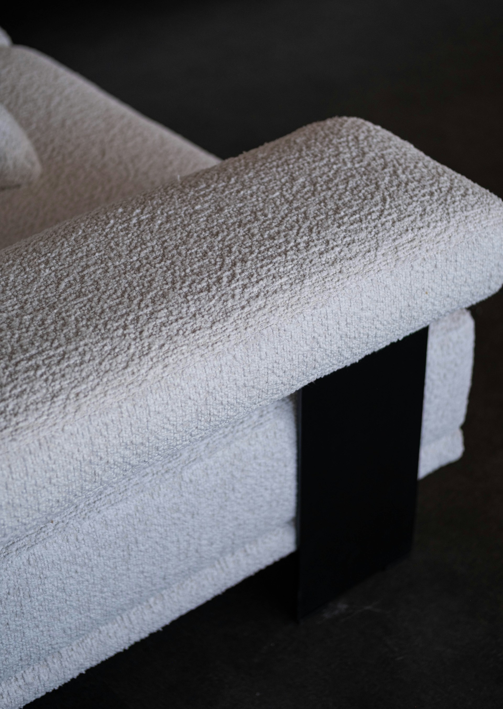 Close up of a textured white armchair with black accent.
