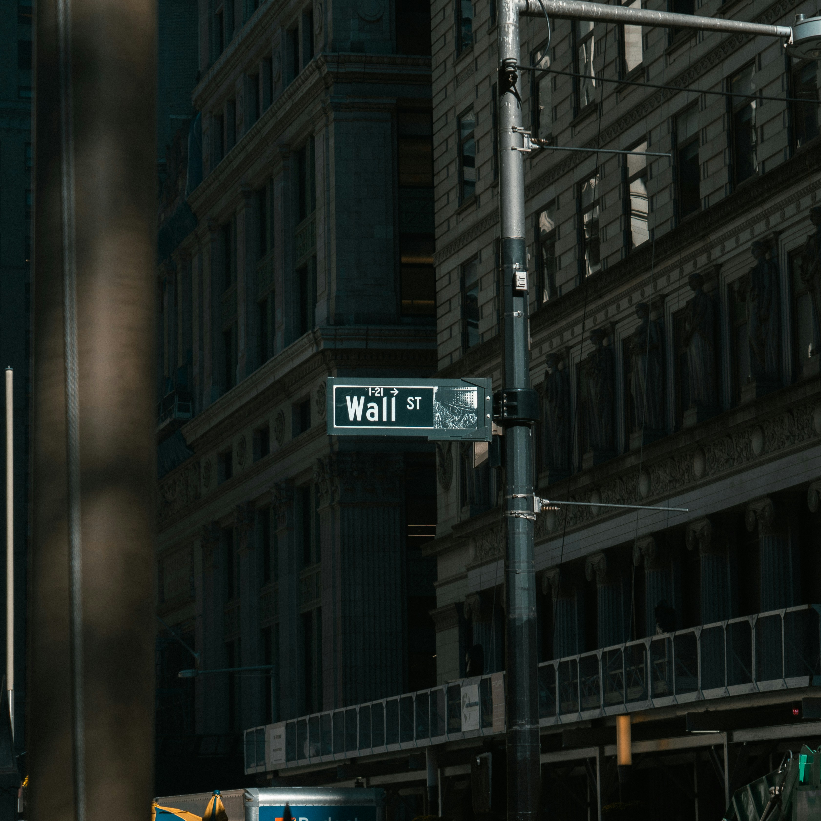 Wall Street sign on a building facade in New York City's financial district