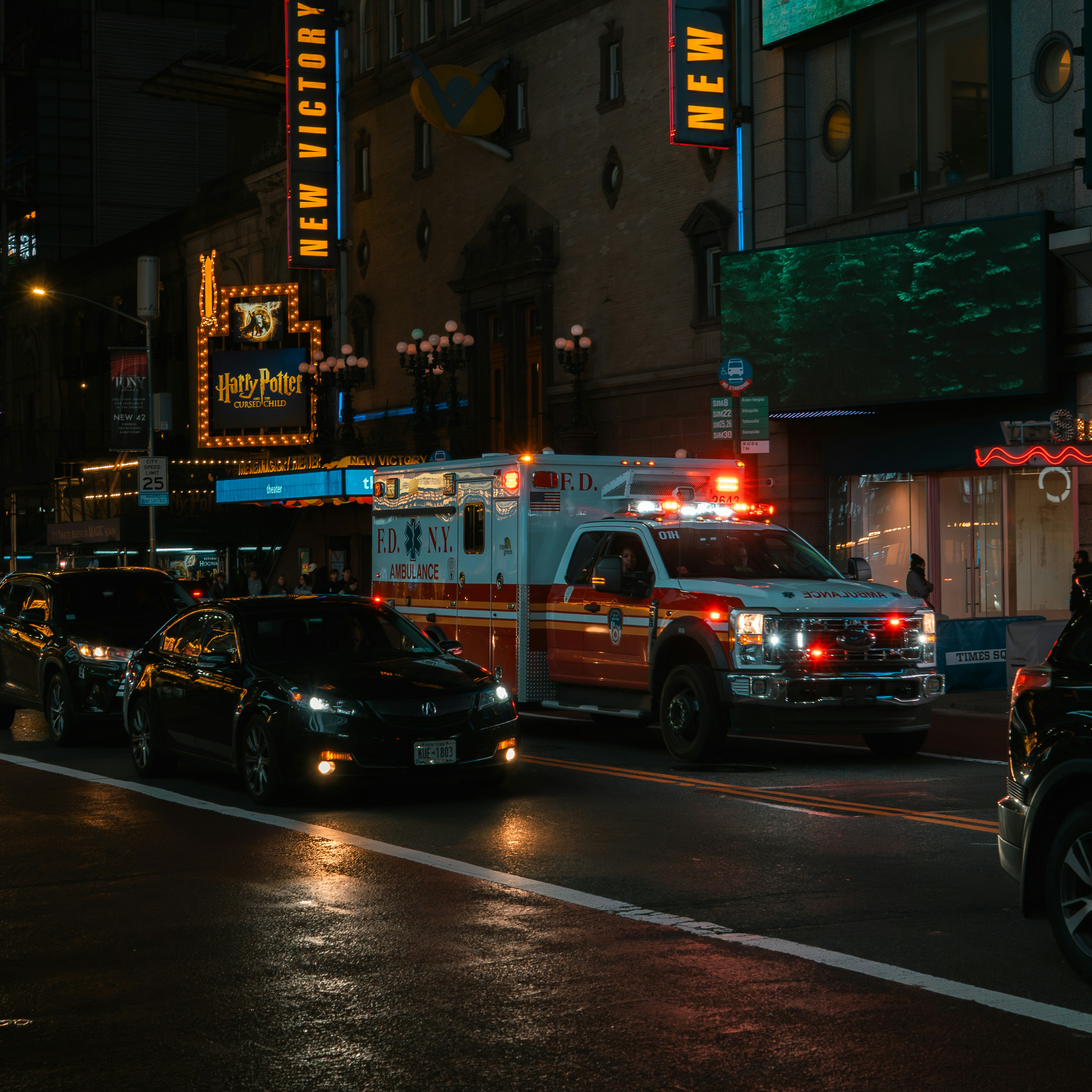 Ambulance with flashing lights on a city street at night.