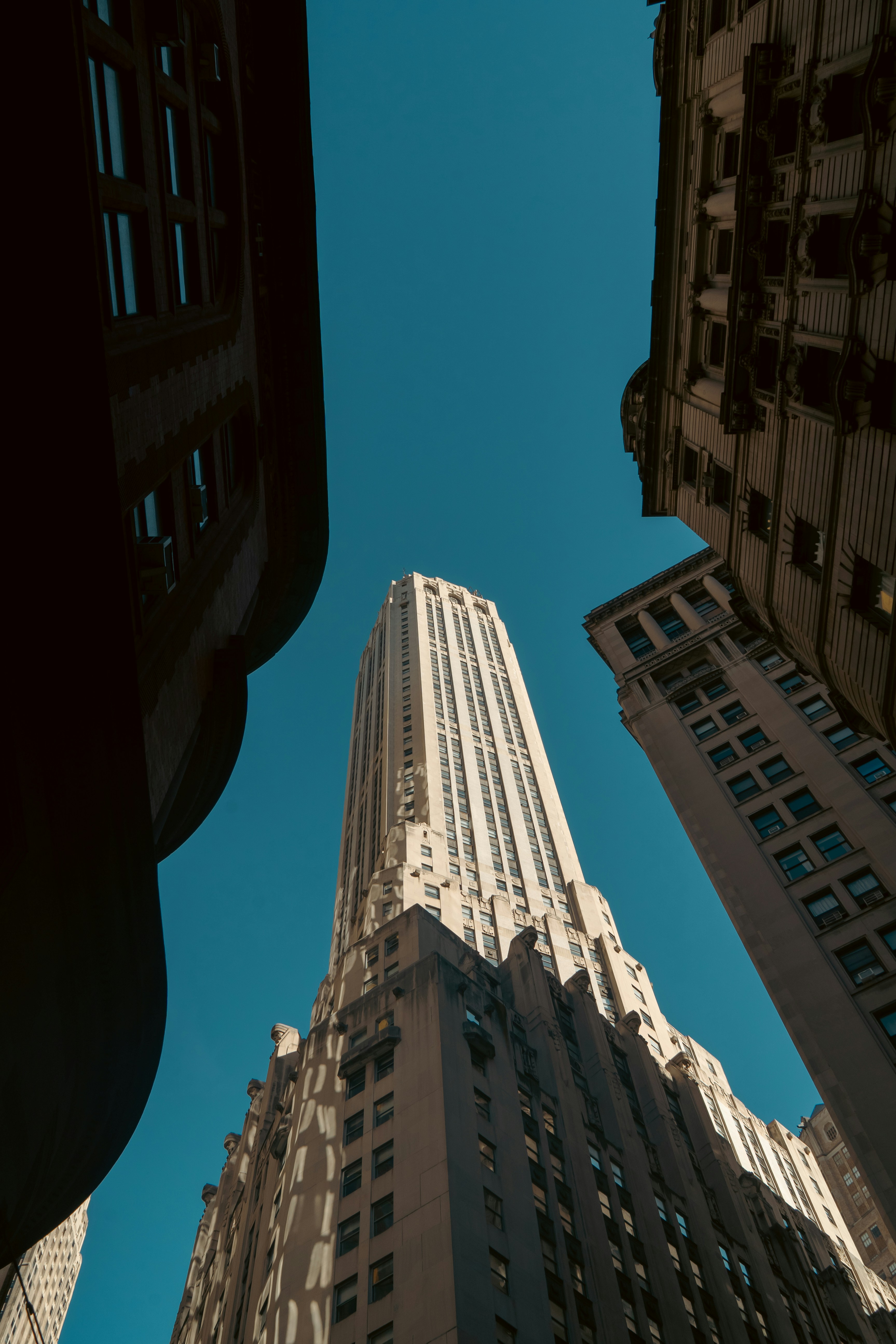 Tall buildings reaching towards a clear blue sky.
