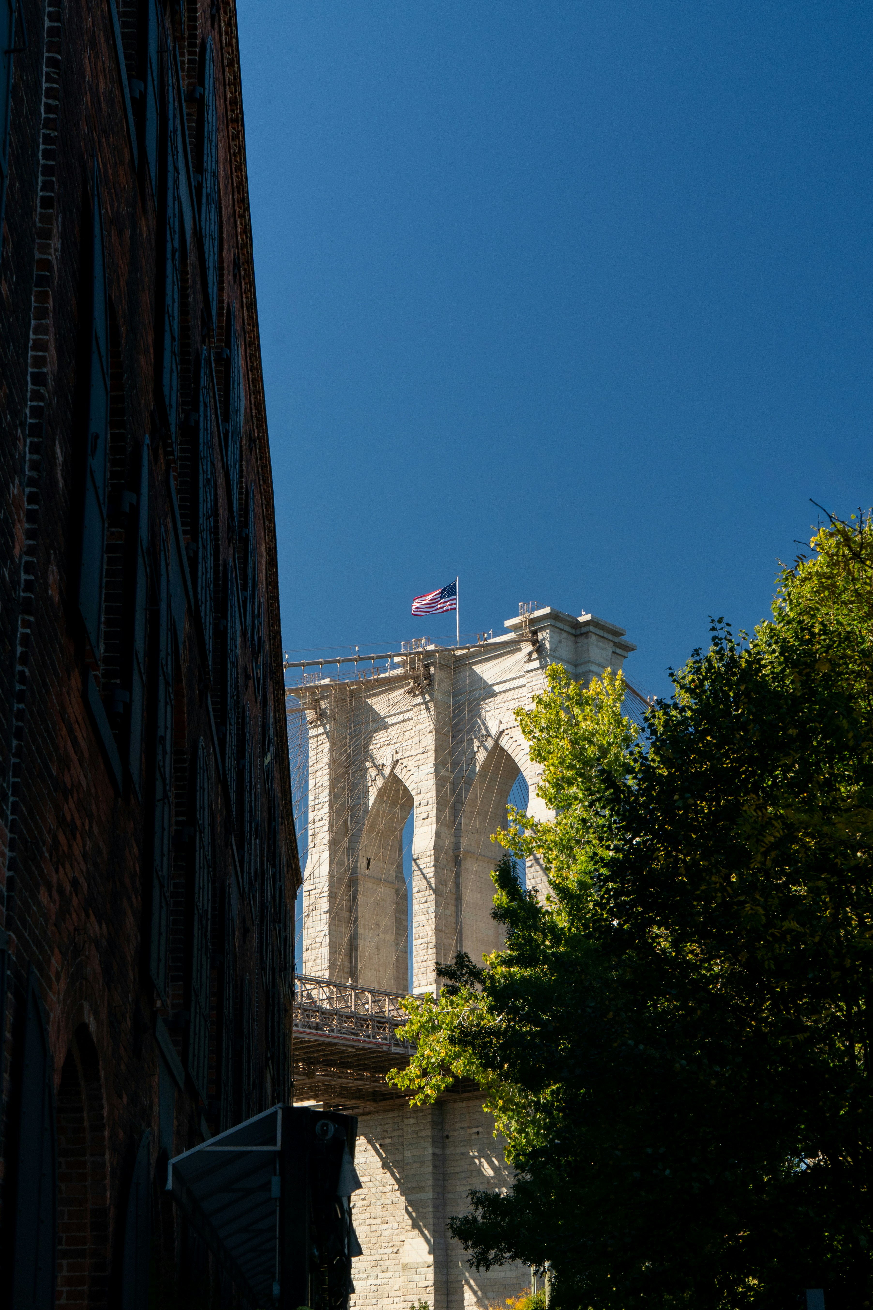 Brooklyn bridge tower against a clear blue sky.