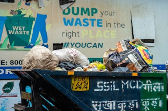Overflowing dumpster with trash and a sign