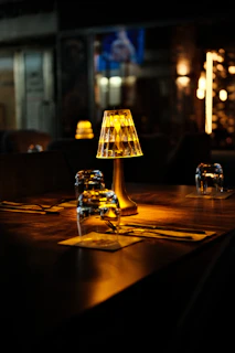 Table setting with illuminated lamp in dim restaurant