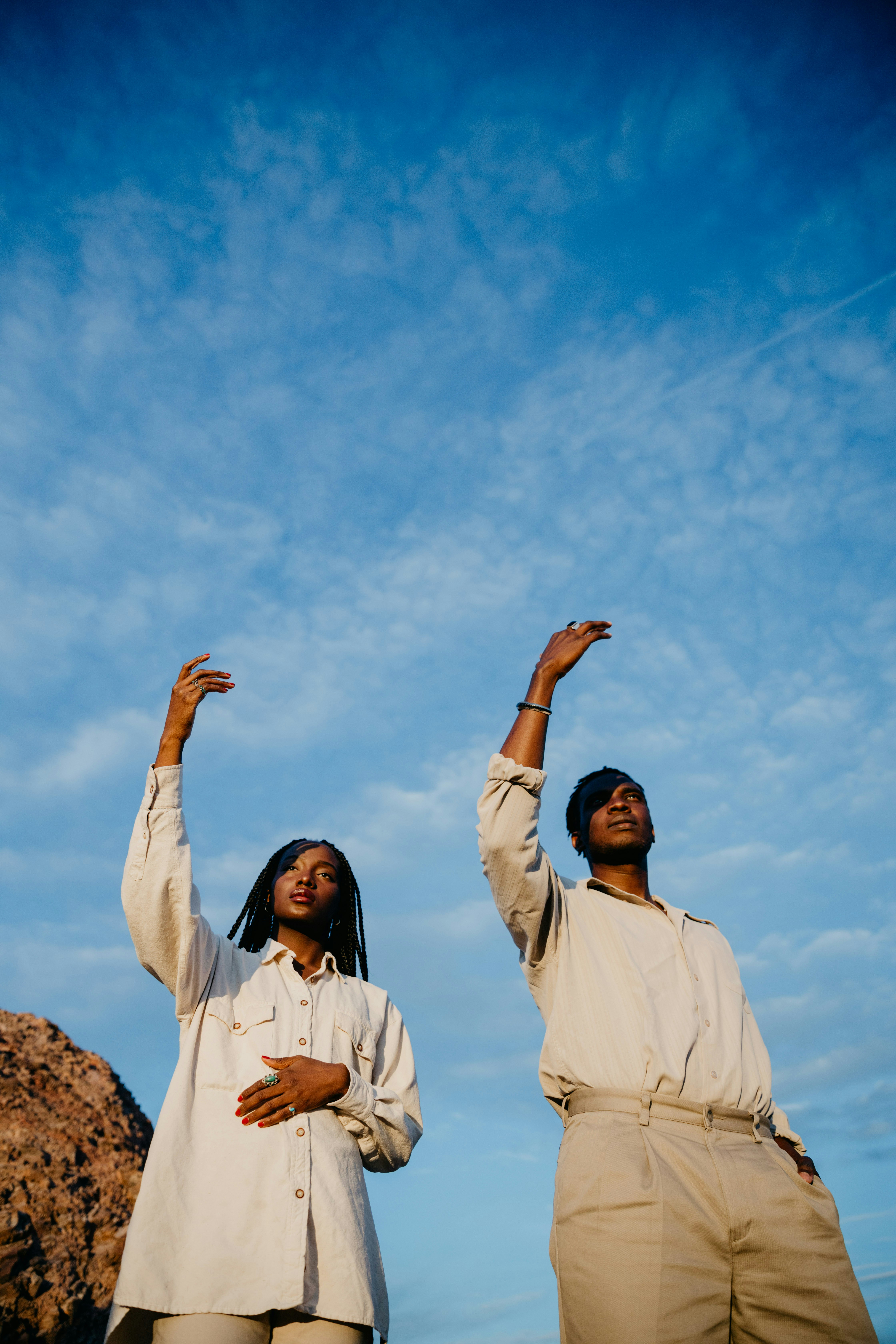 Two people dancing under a blue sky