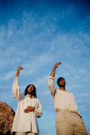 Two people dancing under a blue sky