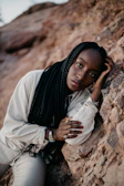 Young black woman with braided hair resting on rocks