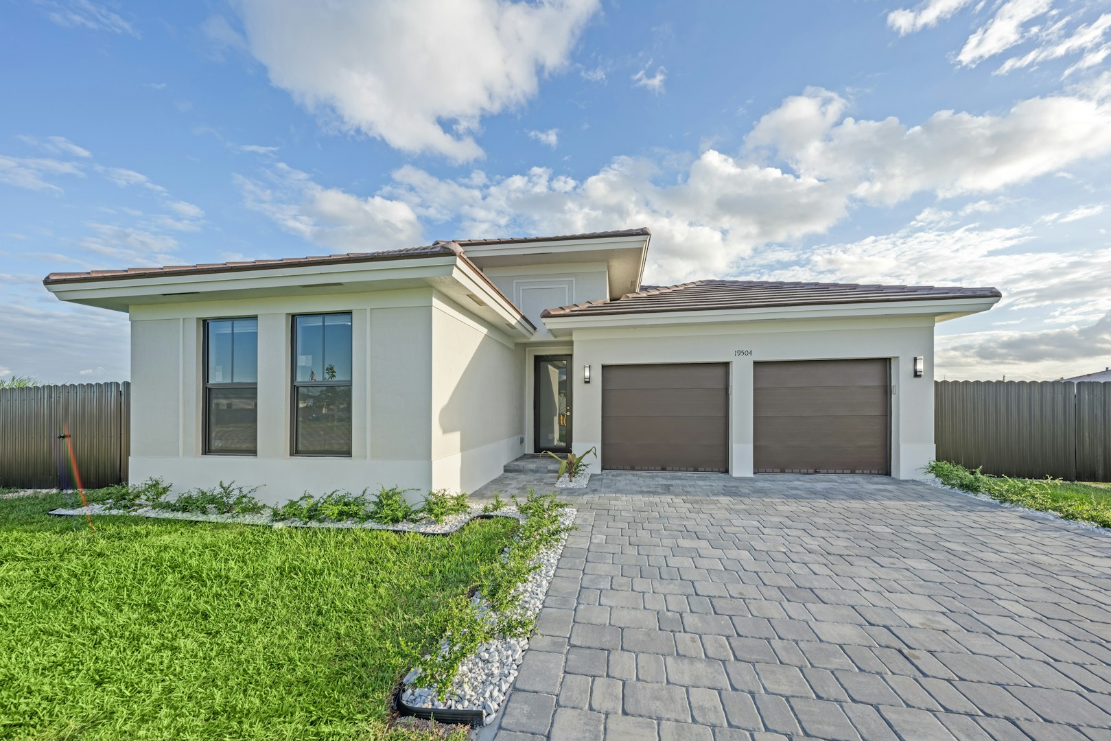Modern single-story home with a paver driveway and two-car garage