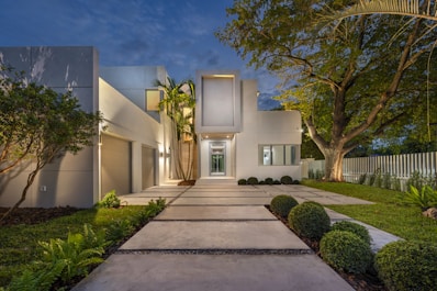 Modern white house with illuminated pathway at dusk