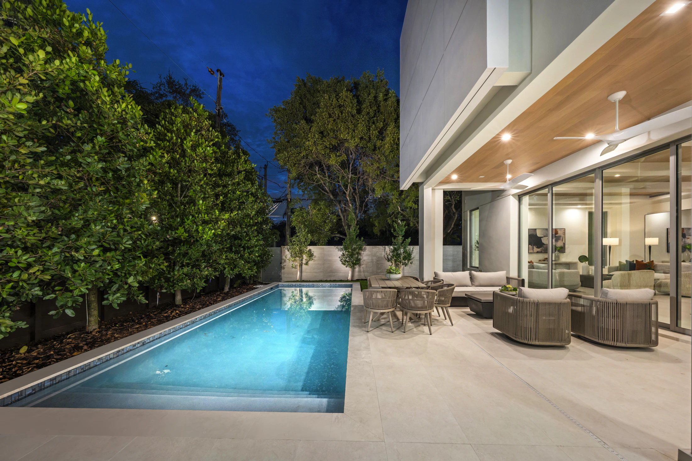 Modern rectangular backyard pool beside a contemporary home at dusk