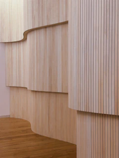 Curving wooden walls with vertical slats and wooden floor.