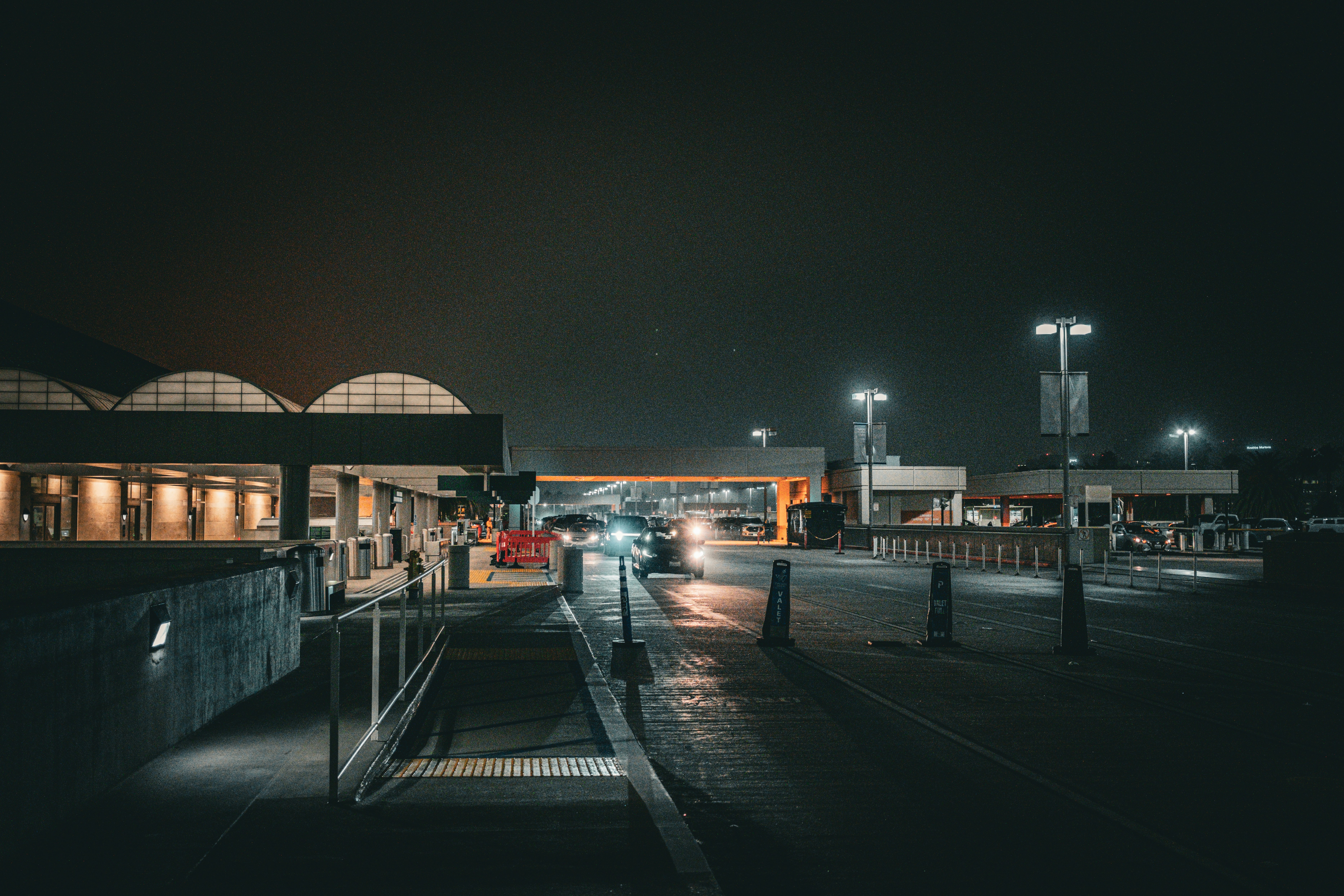 Airport terminal at night with cars driving