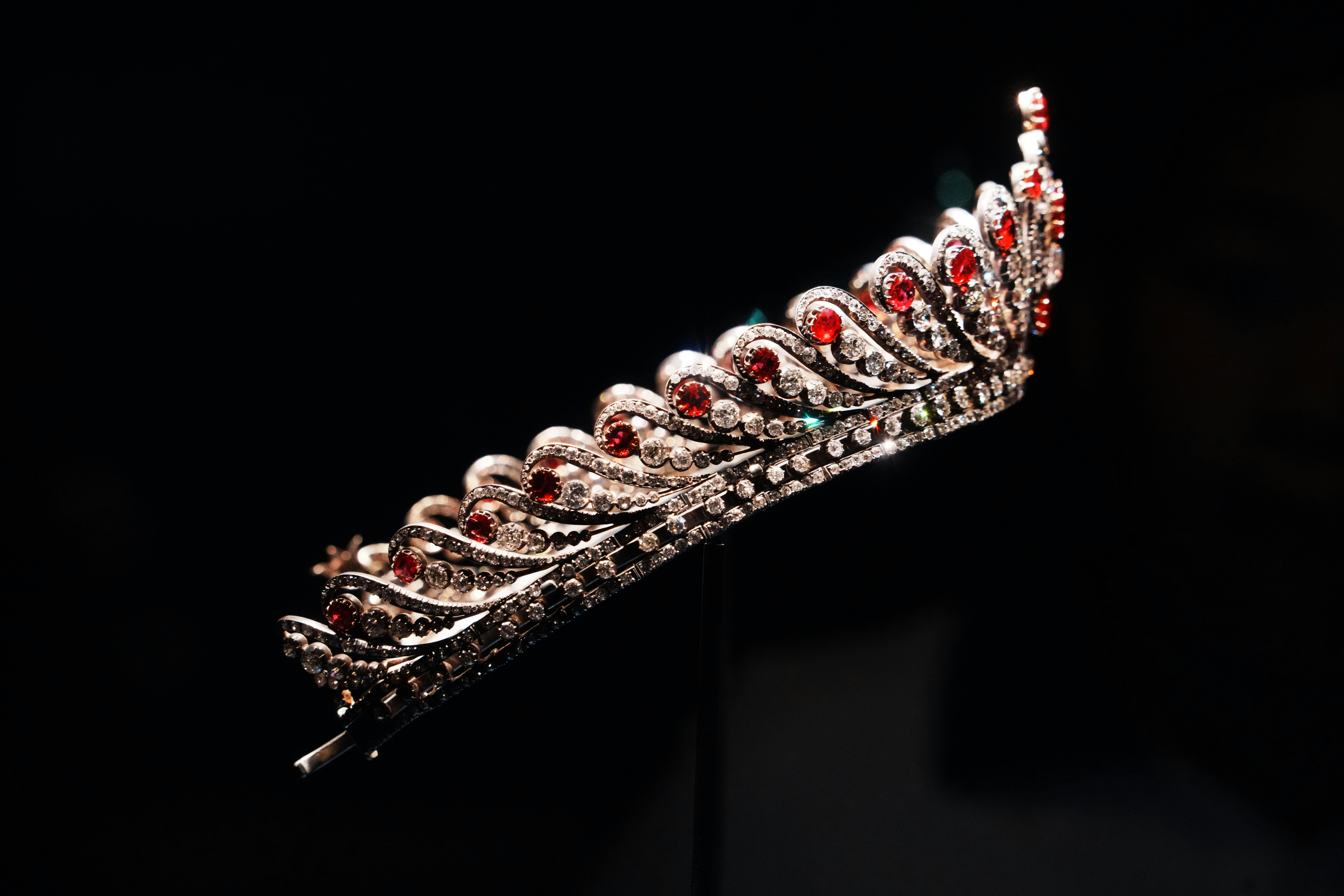 Ornate tiara with red gemstones on black background
