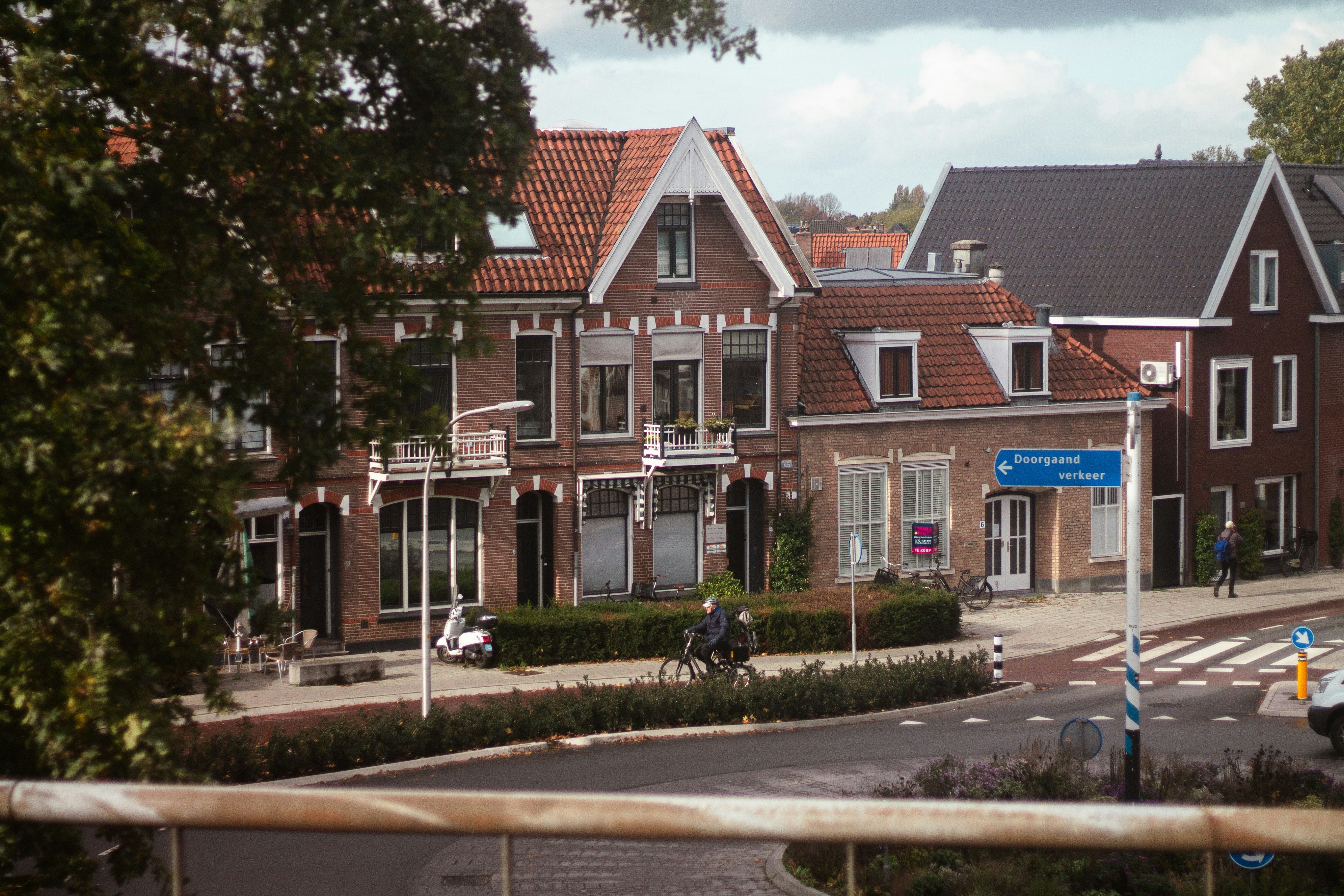 Street view with brick houses and people cycling.