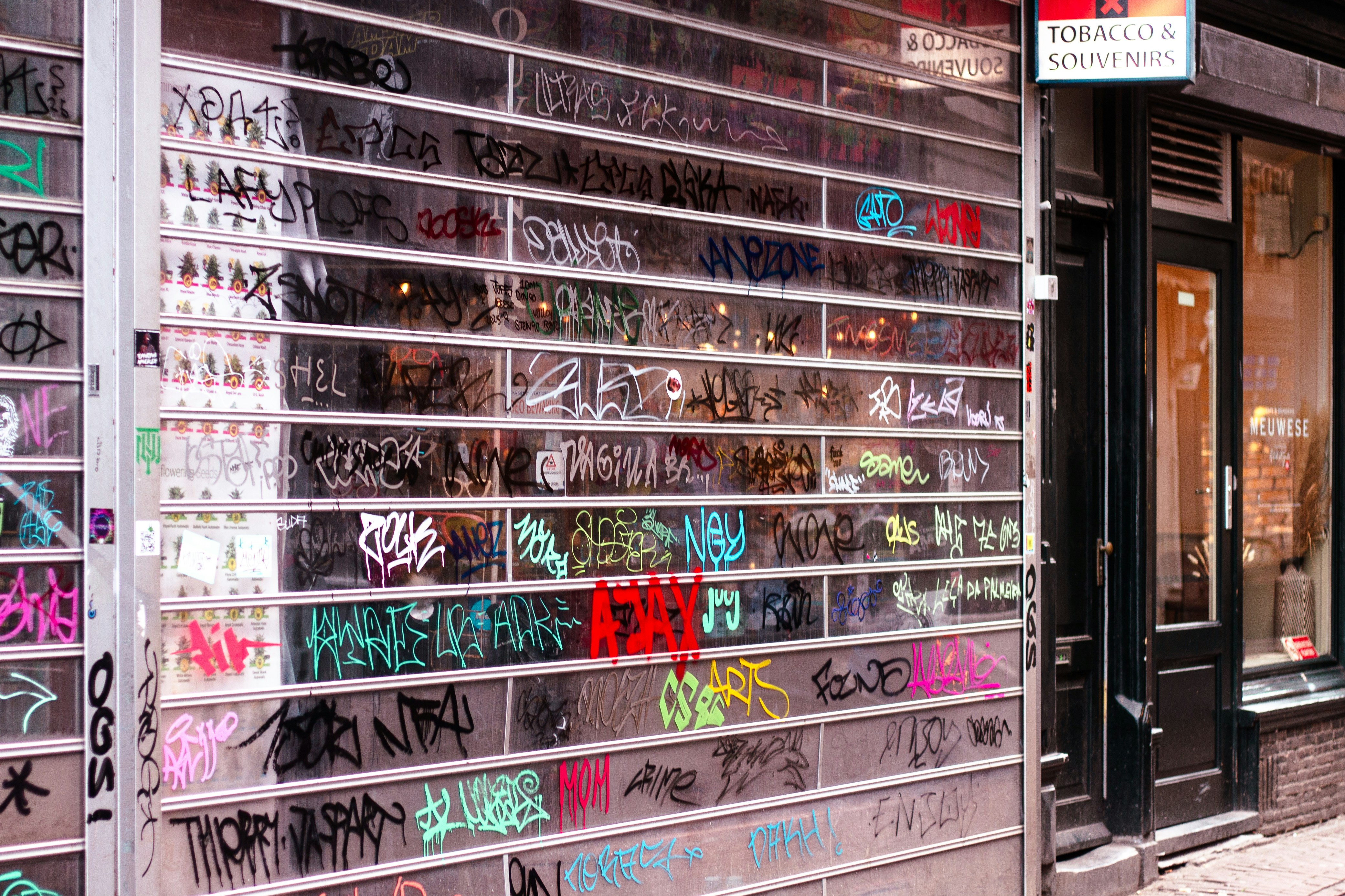 Clear rolling gate covered in colorful graffiti tags