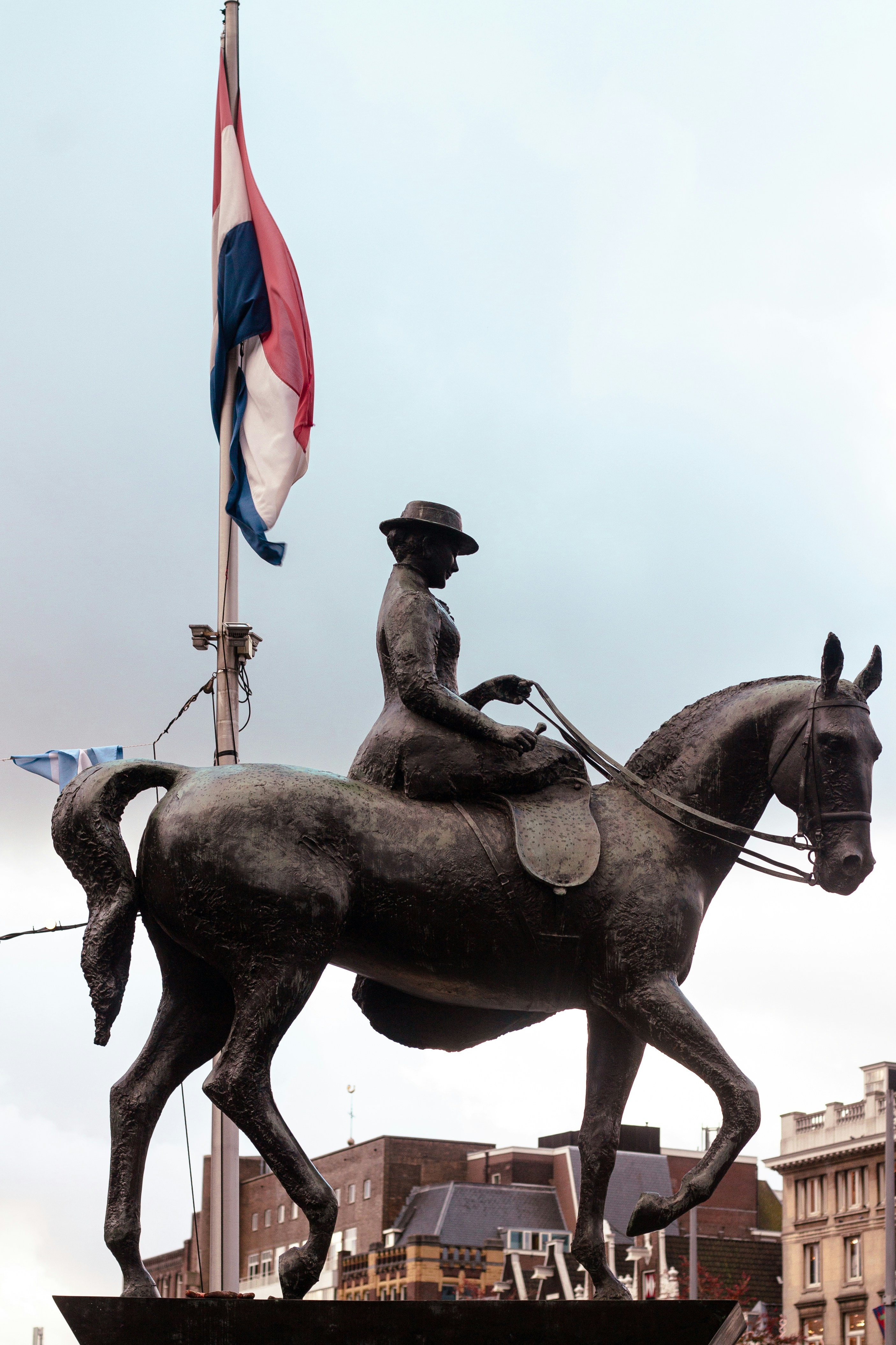 Equestrian statue with dutch flag and buildings