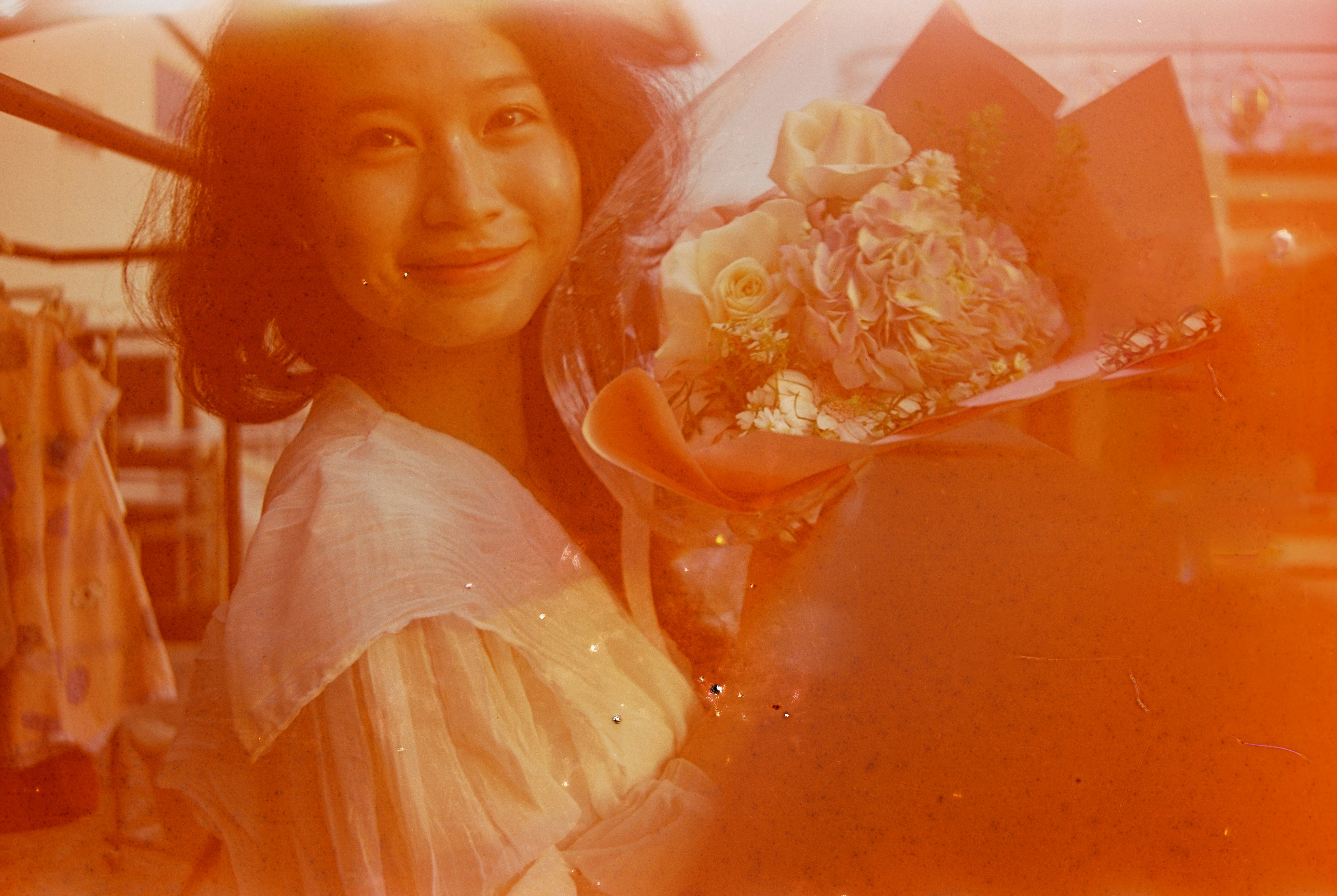 A smiling woman holds a bouquet of flowers.