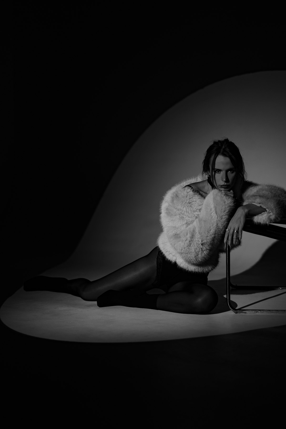 Fashion portrait with moody directional side lighting and strong shadow play