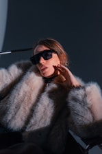 Woman in fur coat and sunglasses posing