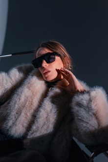 Woman in fur coat and sunglasses posing