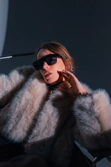Woman in fur coat and sunglasses posing