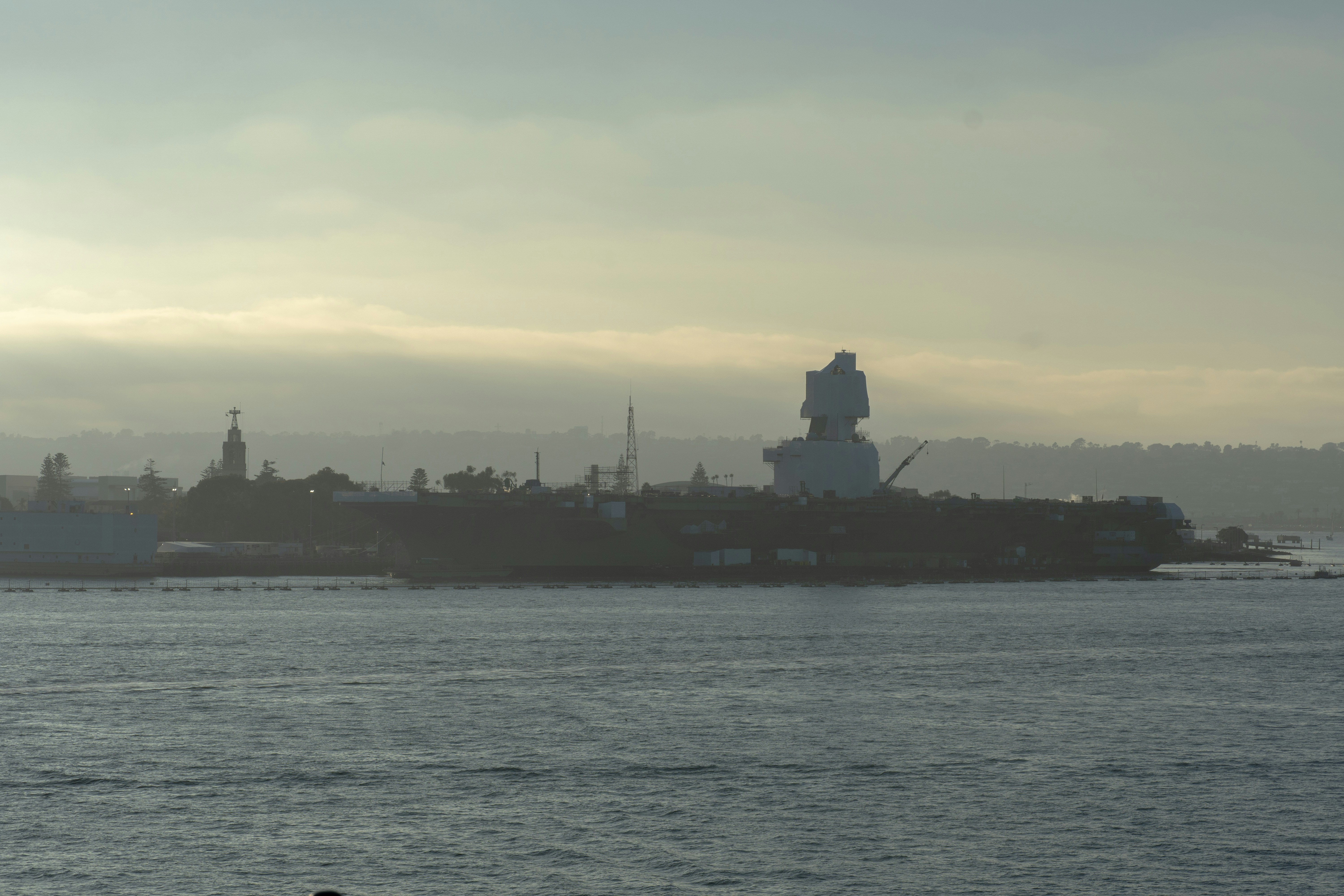 Large white structure on island with hazy sky.