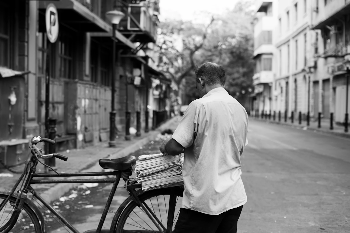 A courier on a bicycle carrying papers