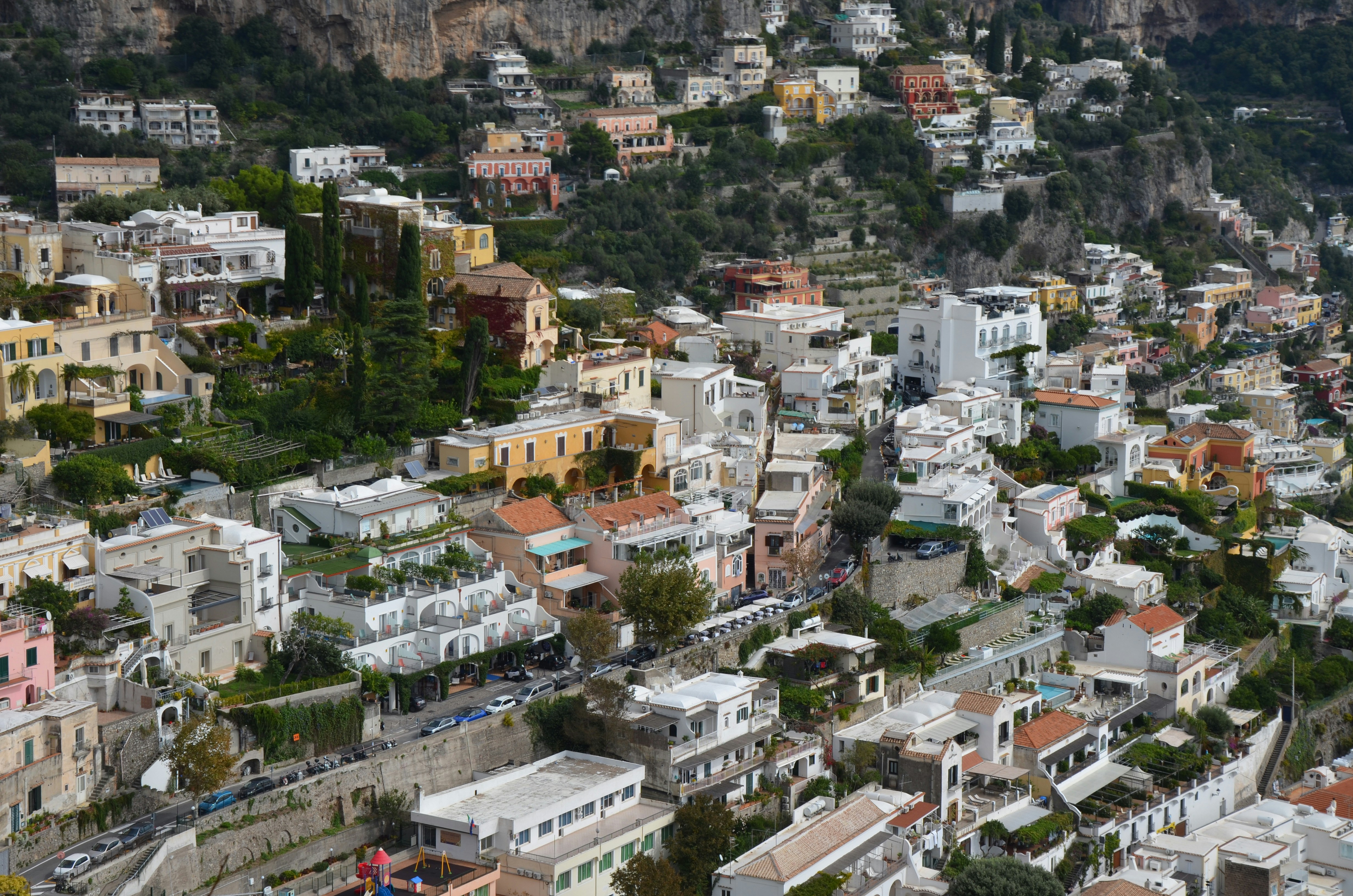 Edificios que caen en cascada por una ladera empinada y verde.
