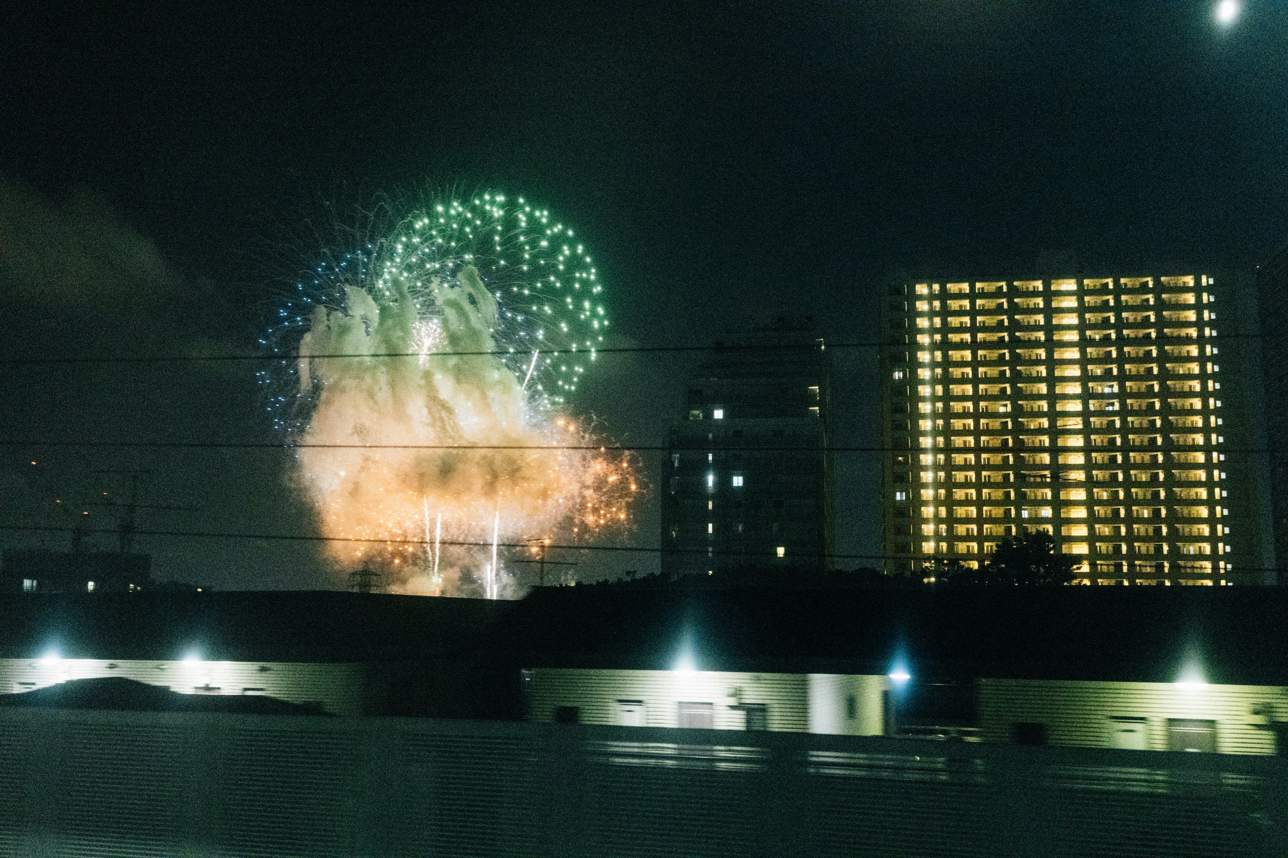 Fireworks explode over city buildings at night. photo – Free Building ...