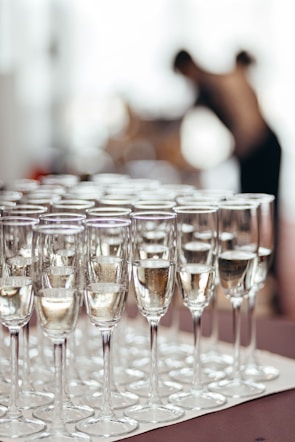 Rows of champagne glasses filled with bubbly liquid.