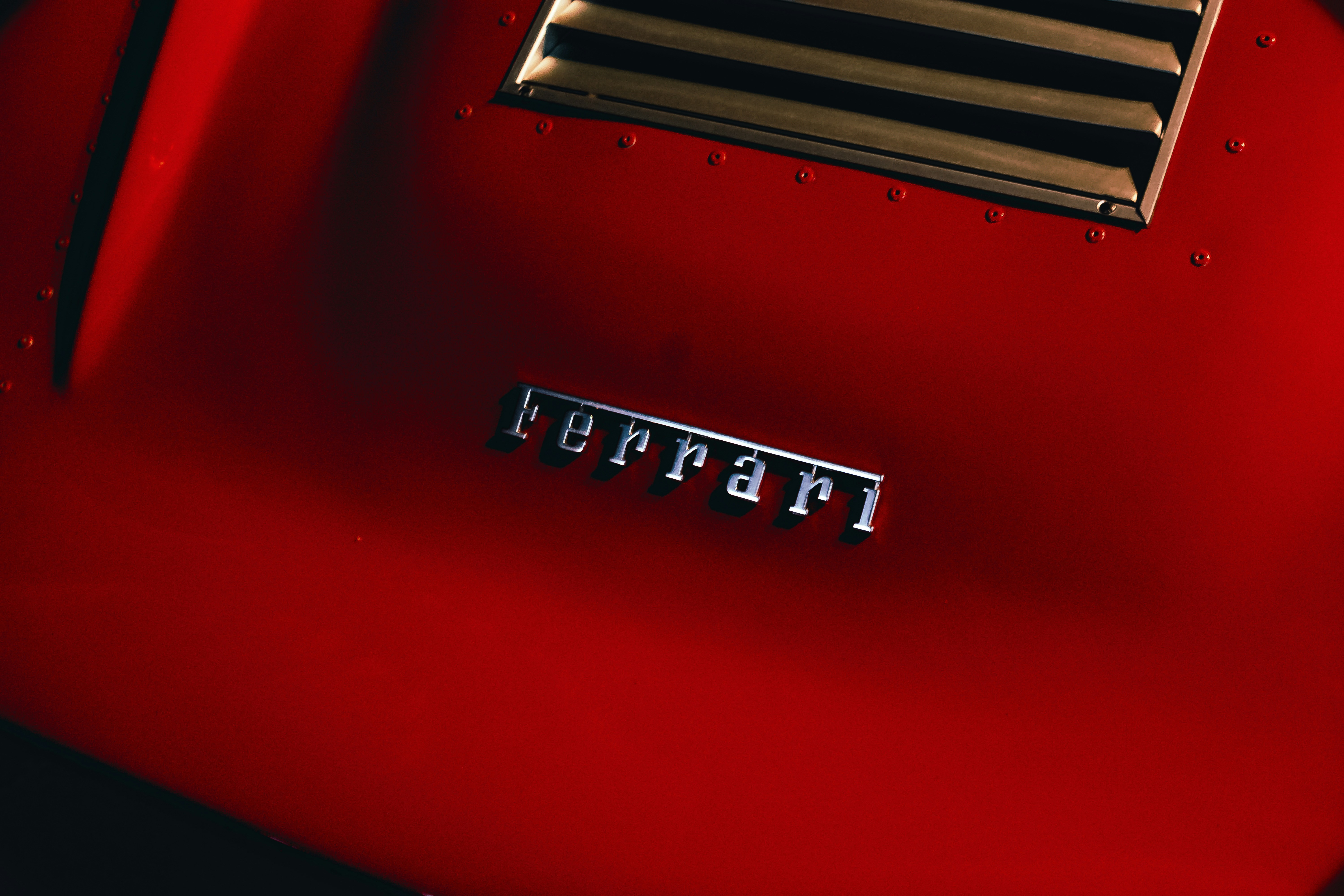 Close-up of a red ferrari car emblem.