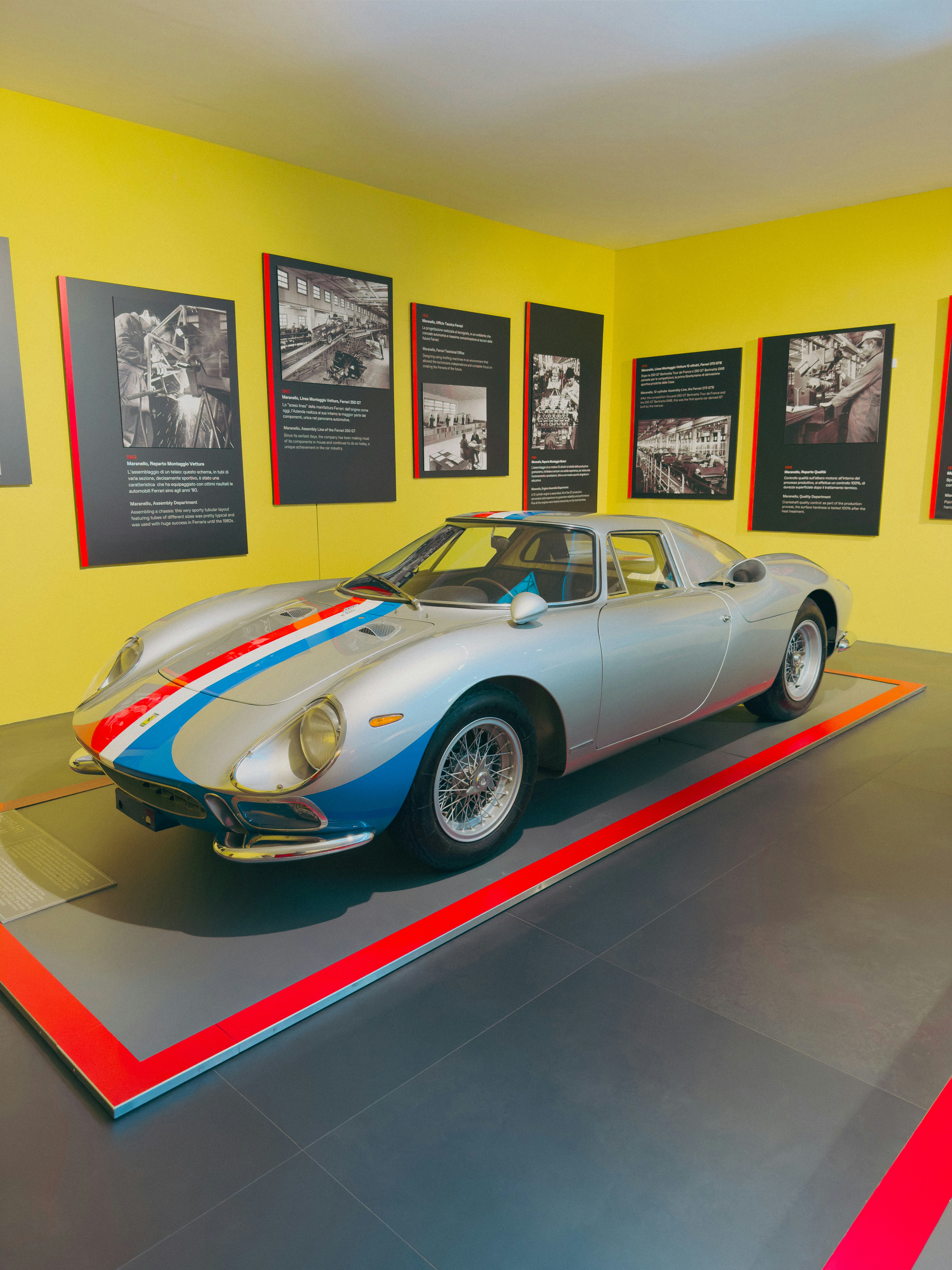 Silver vintage race car with red and blue stripes.