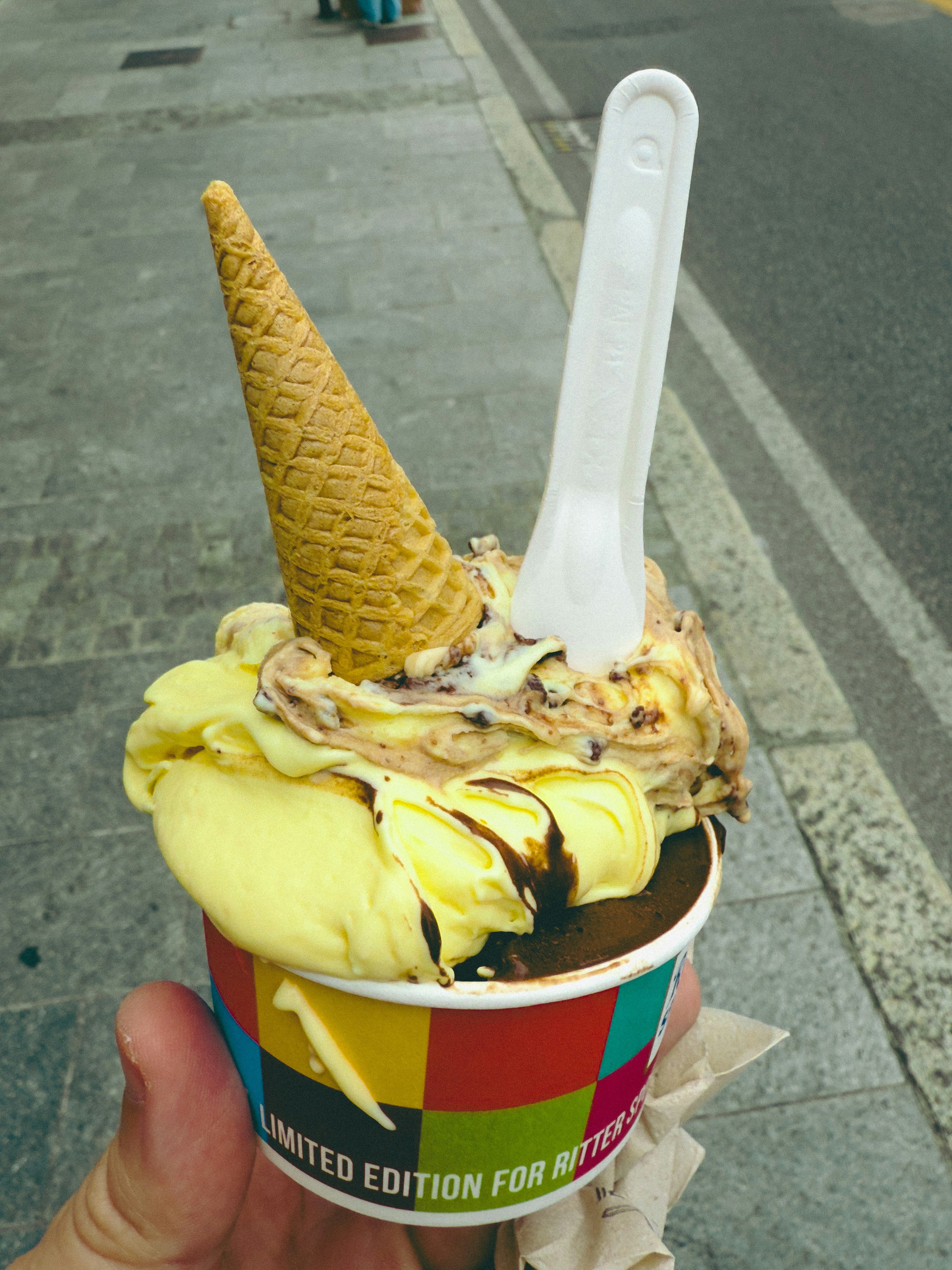 Two scoops of ice cream in a colorful cup