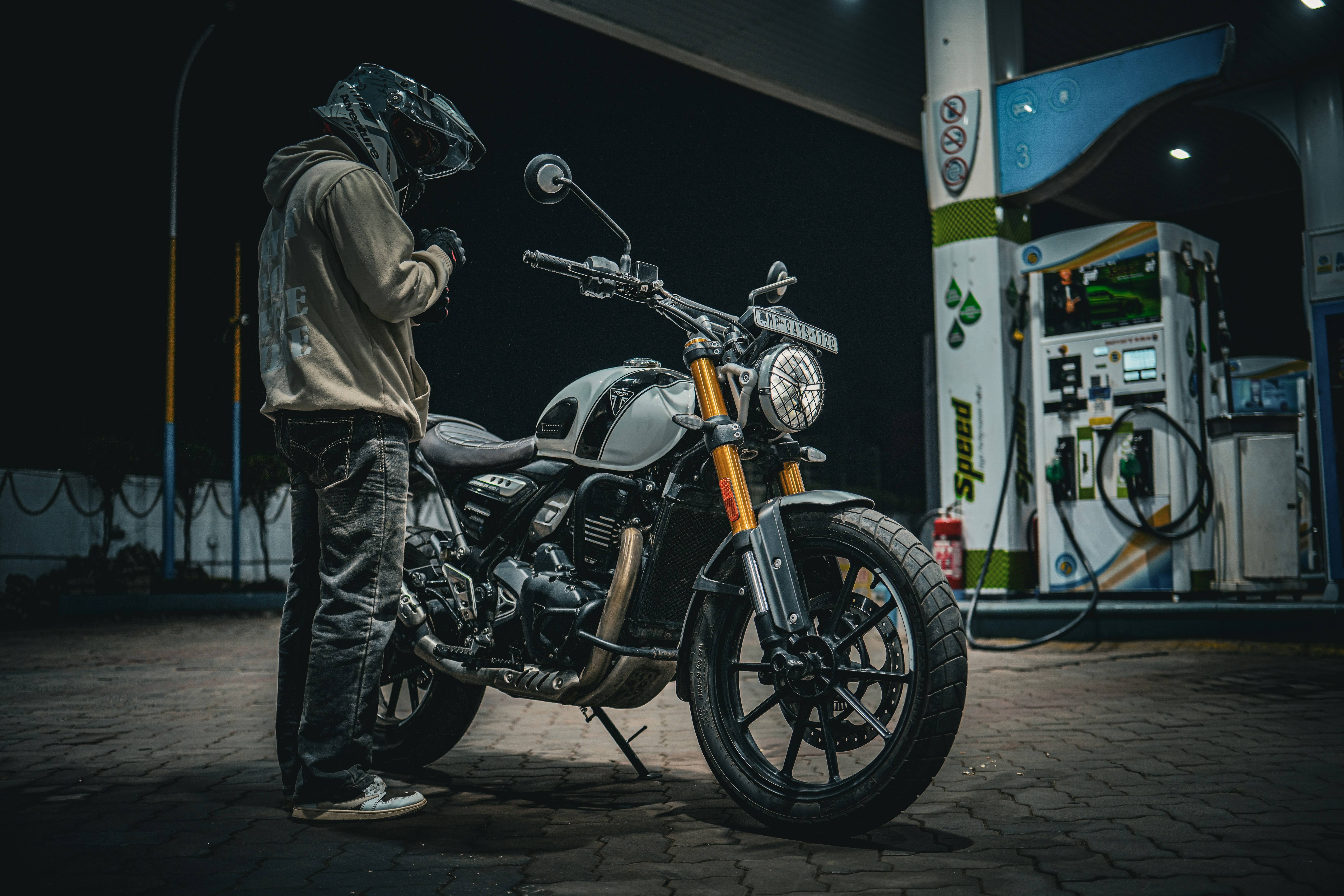 Man in helmet with motorcycle at gas station