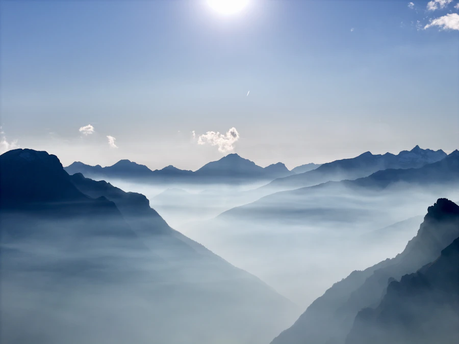 Misty mountains beneath a bright white sky