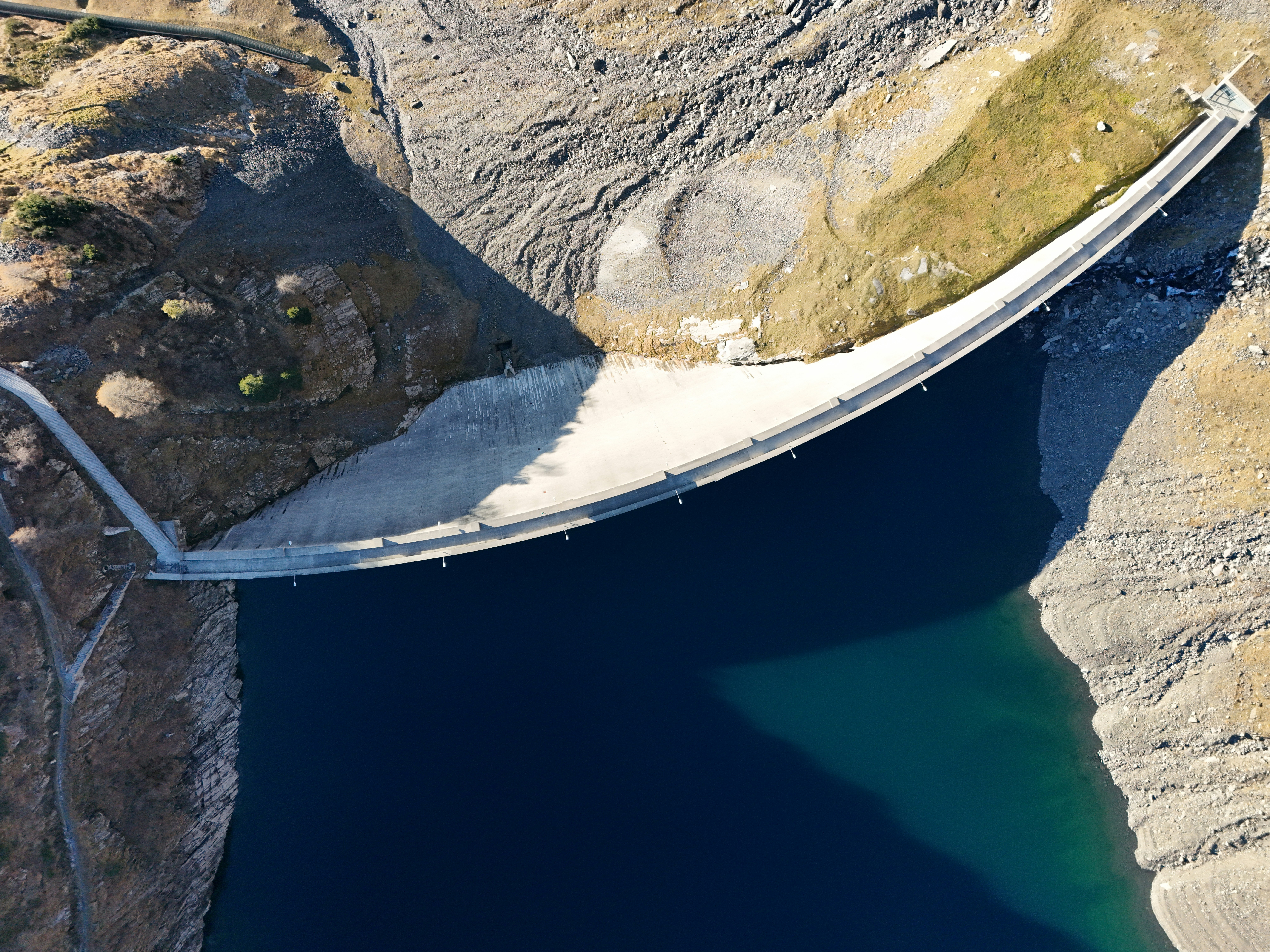 Curved dam with dark blue reservoir
