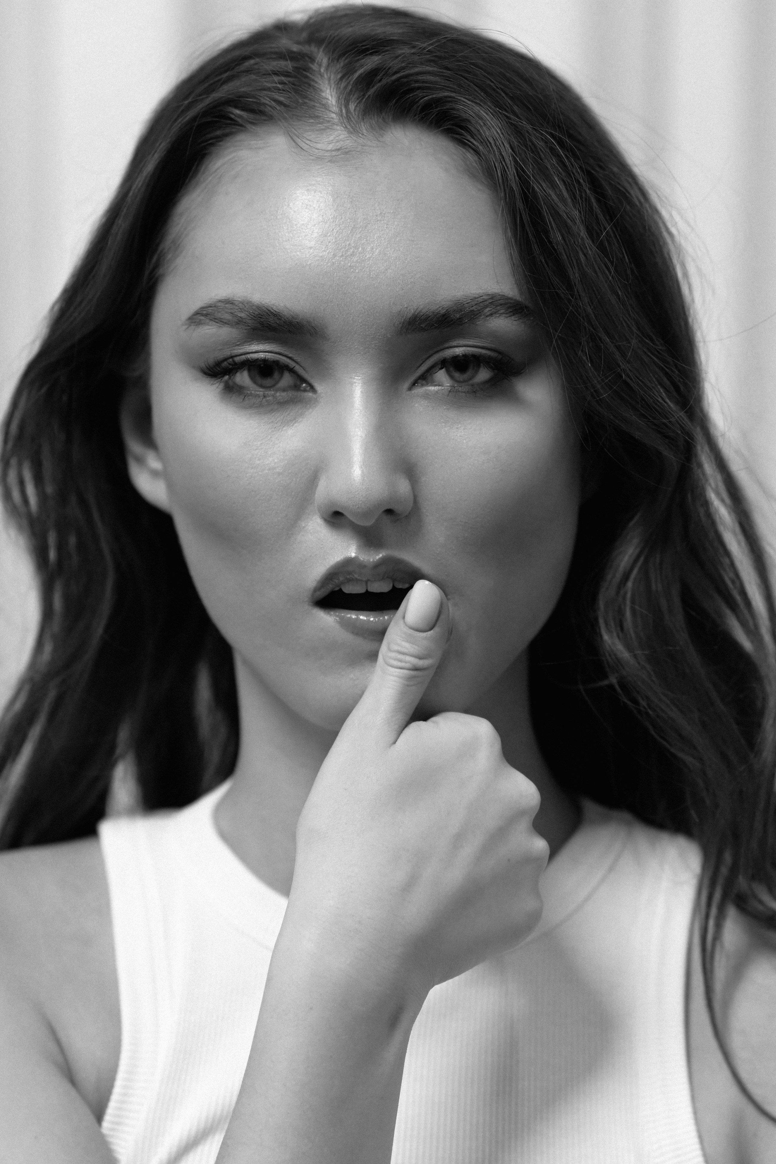Young woman with finger on lips looking intently