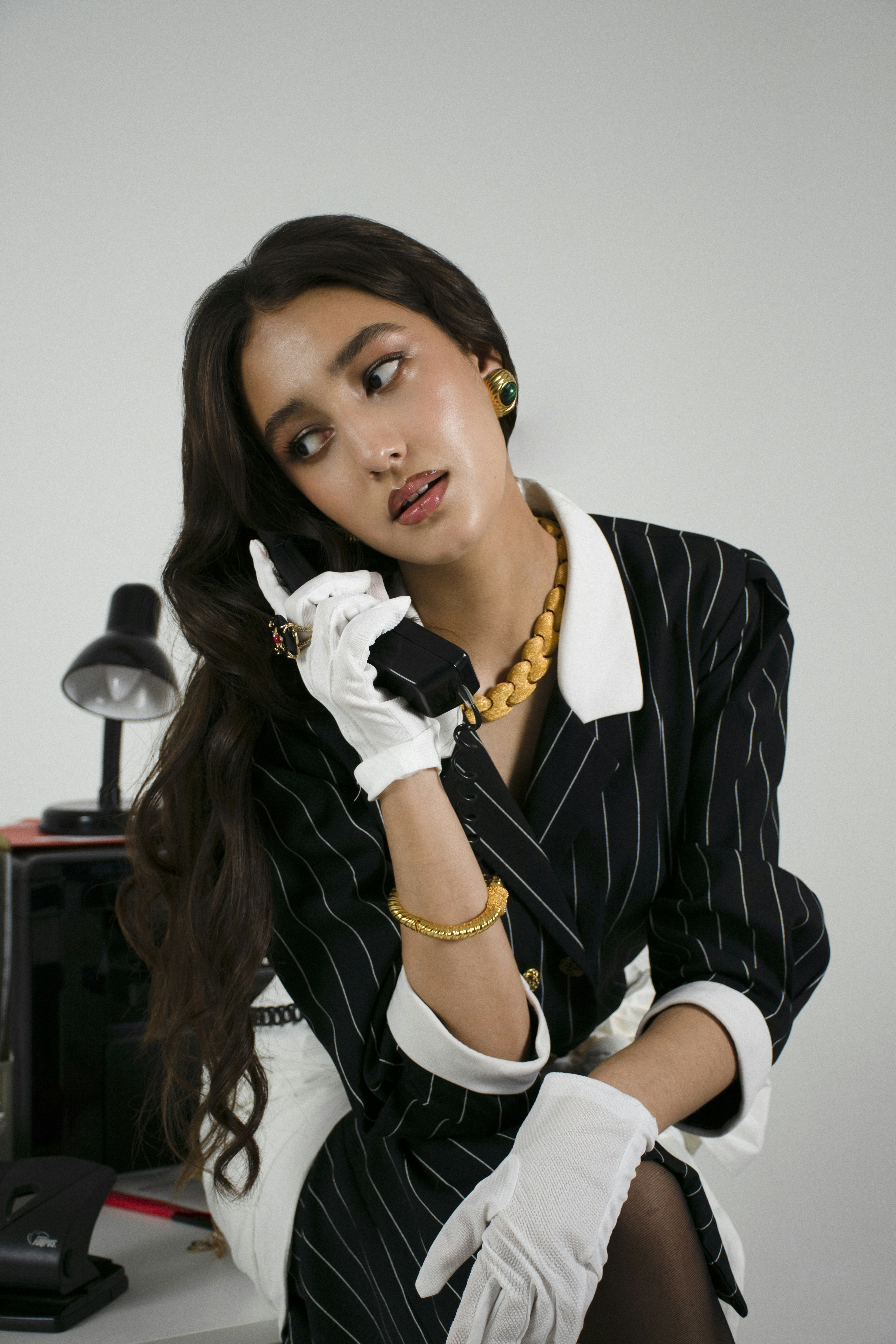 Mulher no terno do vintage que fala no telefone retro