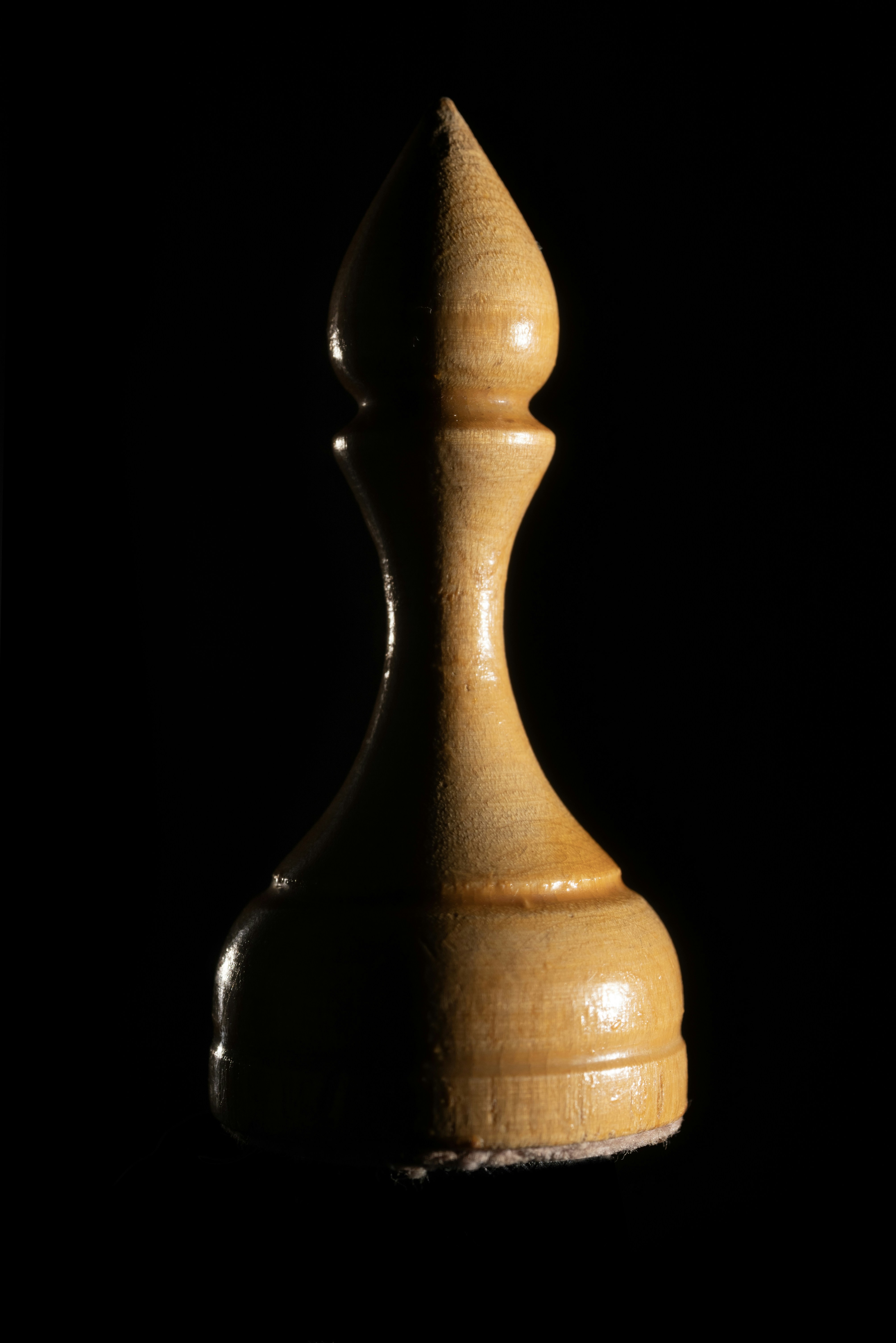 A white chess piece against a black background