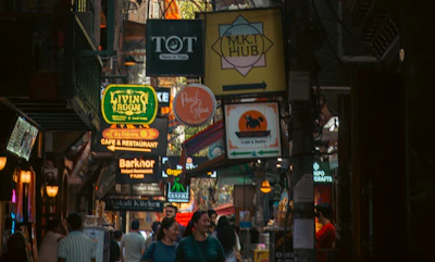 Busy street with many signs and people walking.