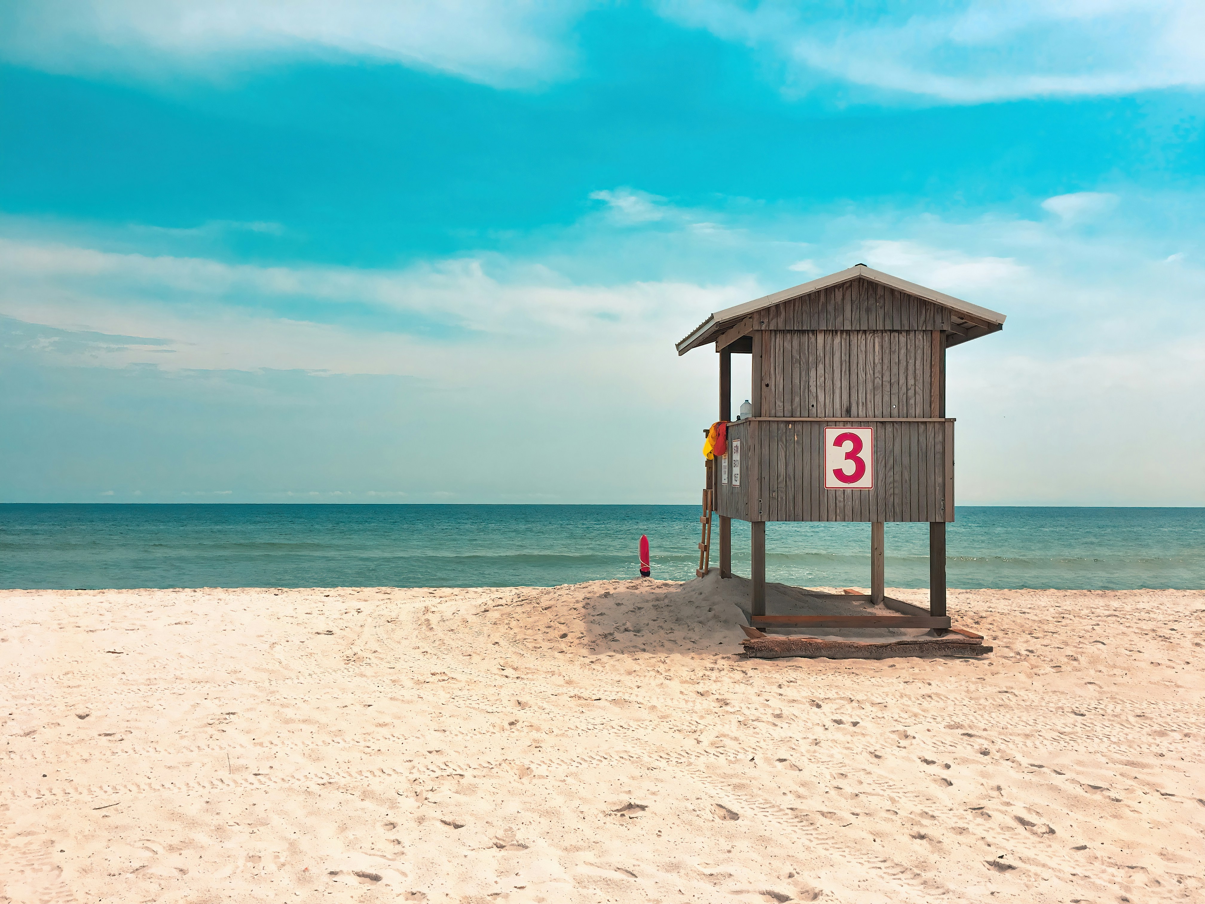 Puesto de socorrista de madera en una playa de arena.