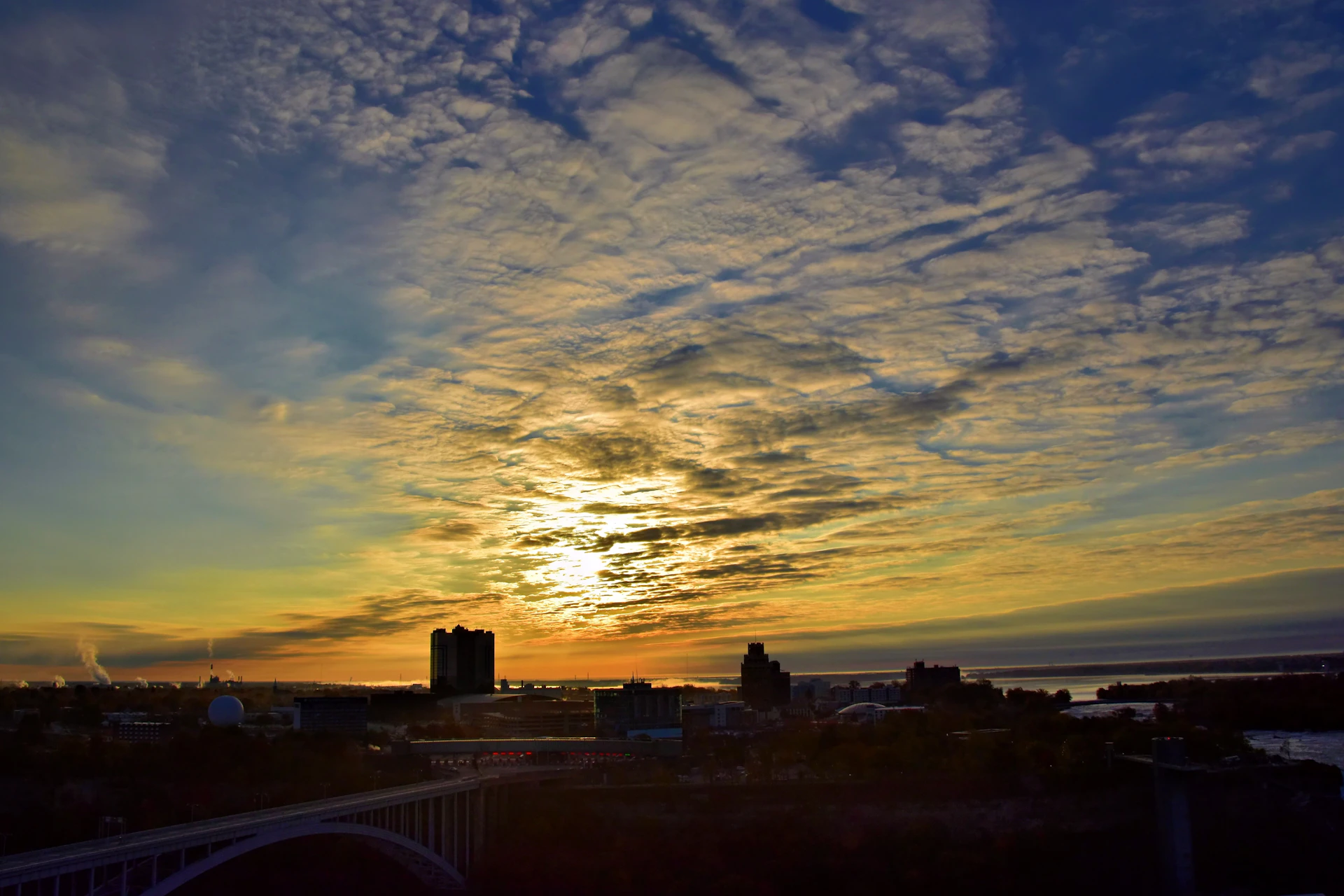 Sunrise over a city skyline with dramatic clouds