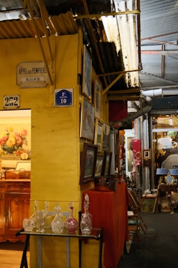 Antiques displayed in a market stall with yellow walls.