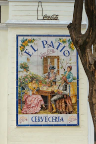 Tiled mural of people dining at el patio cerveceria.