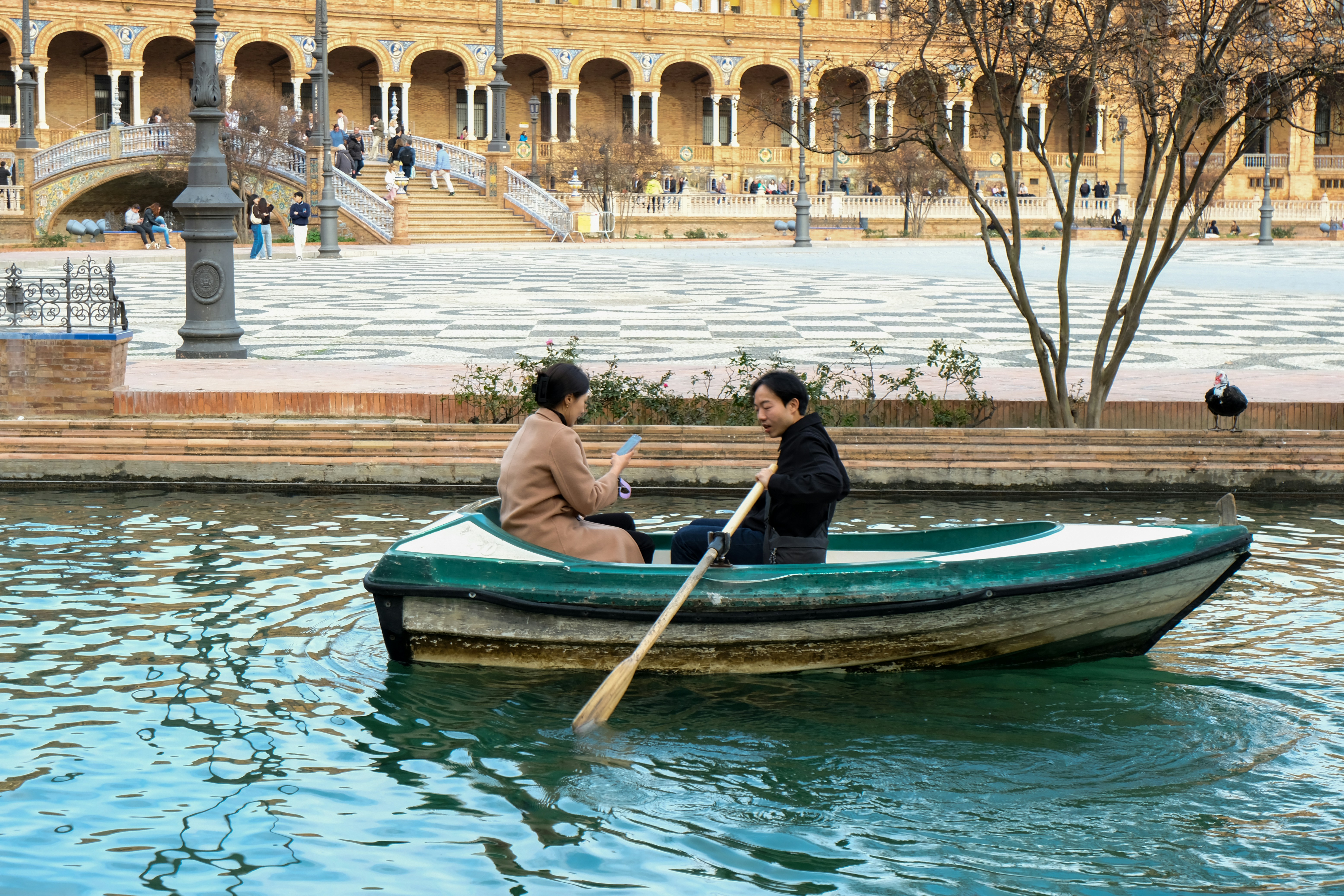 two women rowing a boat on a canal in Seville